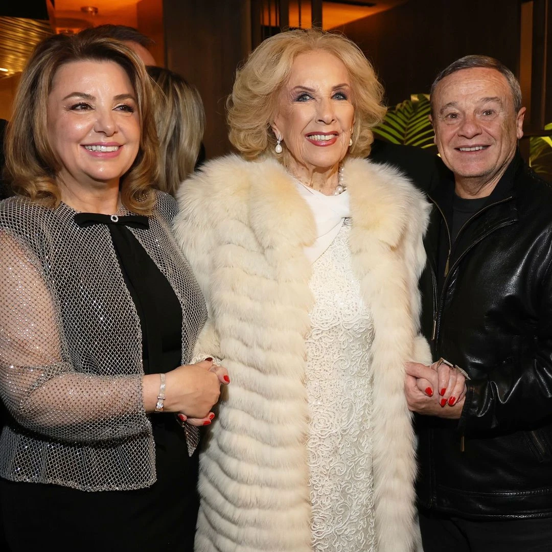 Mirtha Legrand con un tapado color crema y un vestido blanco con detalles bordados. 