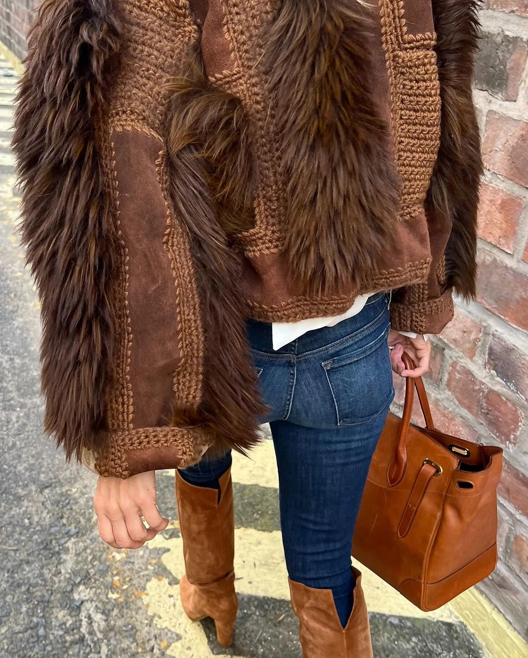 En este look, la modelo eligió un tapado de piel y lana confeccionado artesanalmente de El Camarín, al que combinó con un pantalón denim y botas altas de gamuza. 