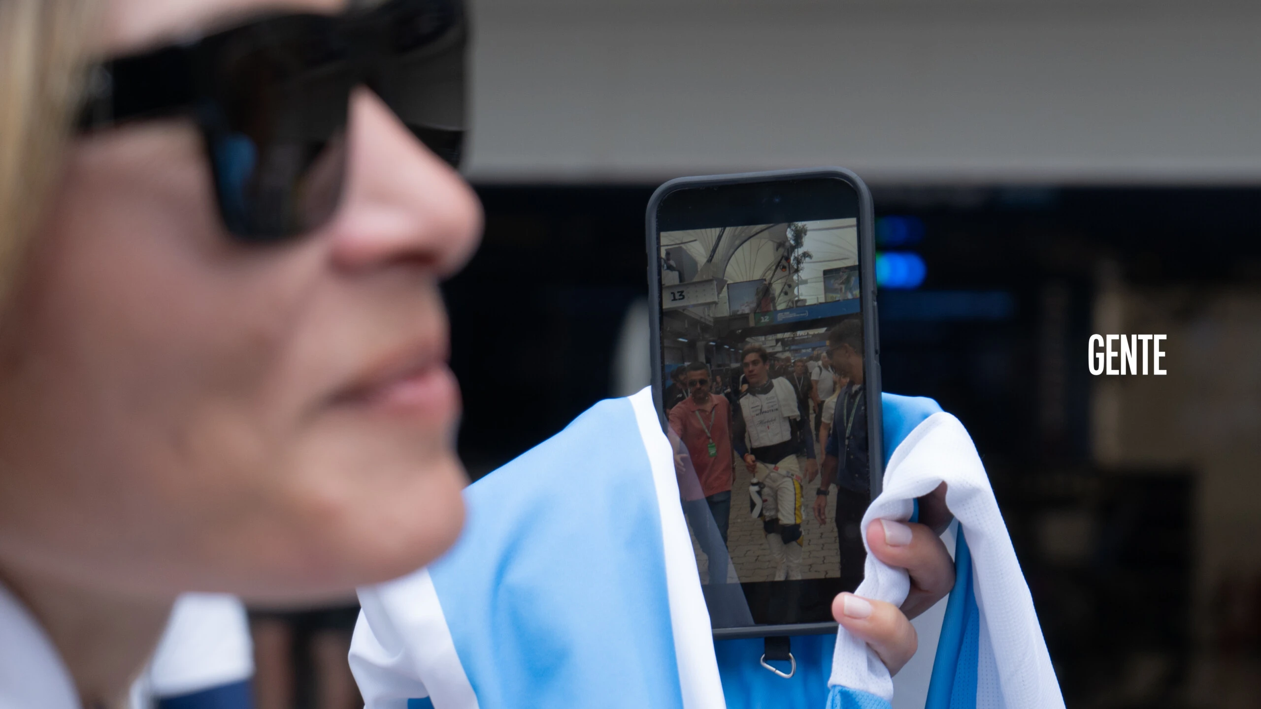 Una argentina, con bandera en mano, muestra orgullosa la foto que le tomó a Franco Colapinto en el padock.